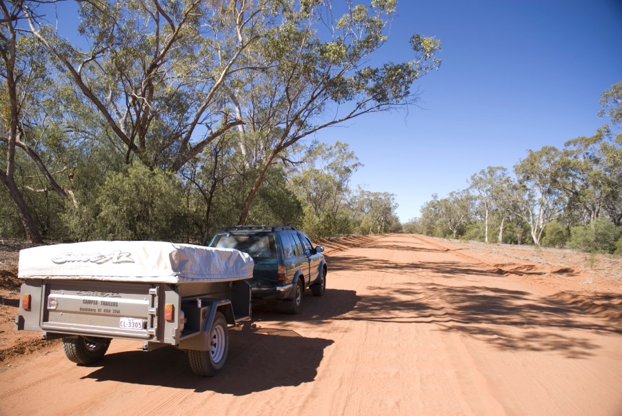 A car with a camper trailer in the desert