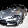 A matte grey Toyota Supra shot from the 3/4 angle at an auto show