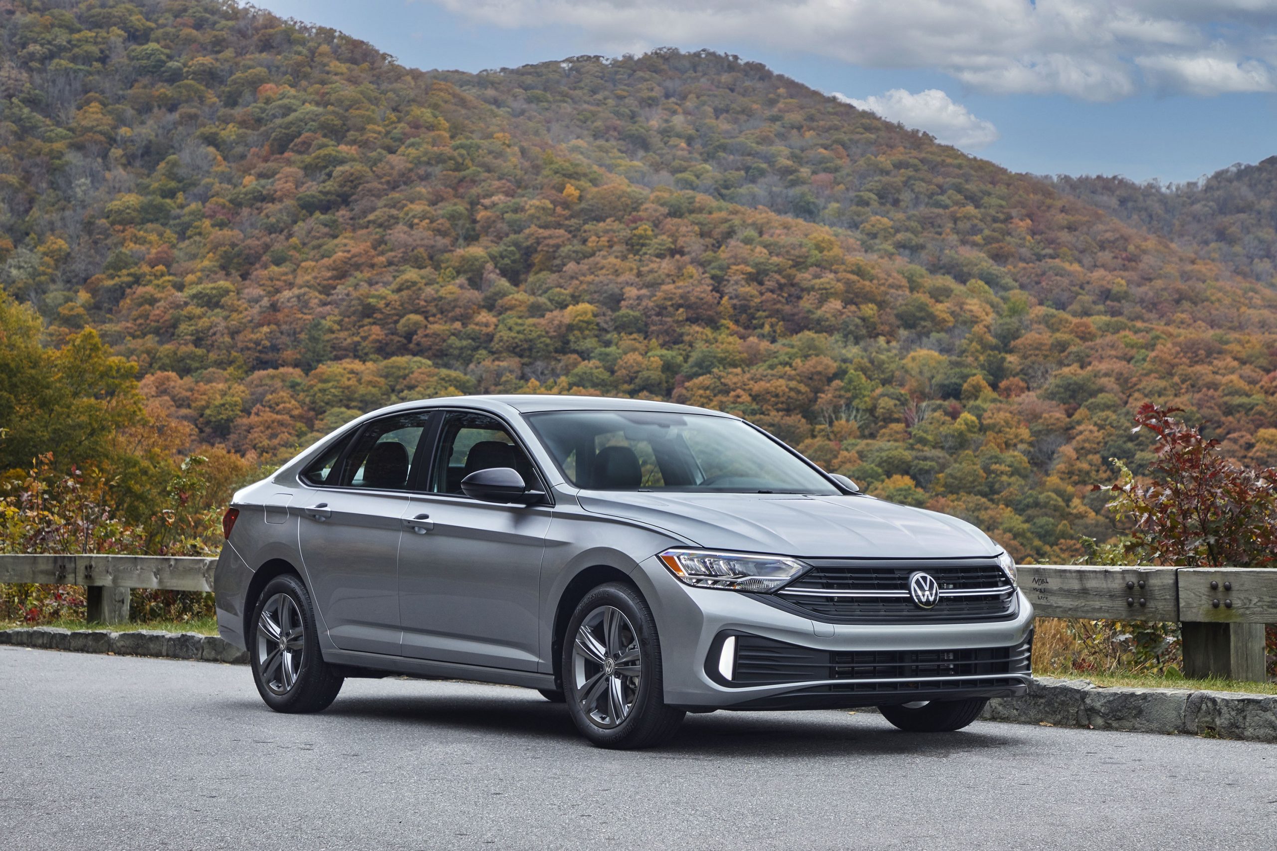 A silver 2022 Volkswagen Jetta shot from the front 3/4 on a country road