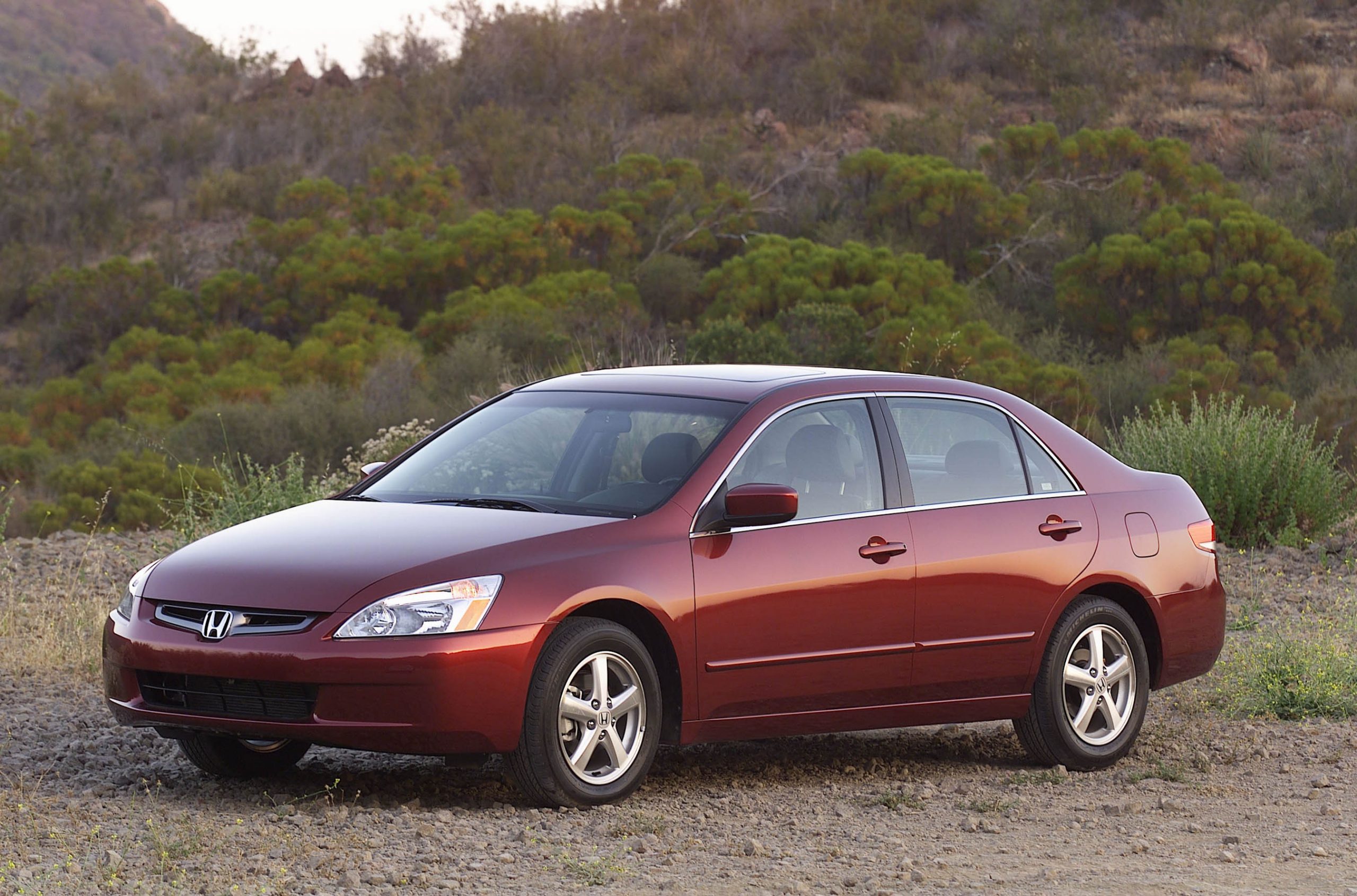 A maroon Honda Accord sedan shot from the front 3/4 during the golden hour