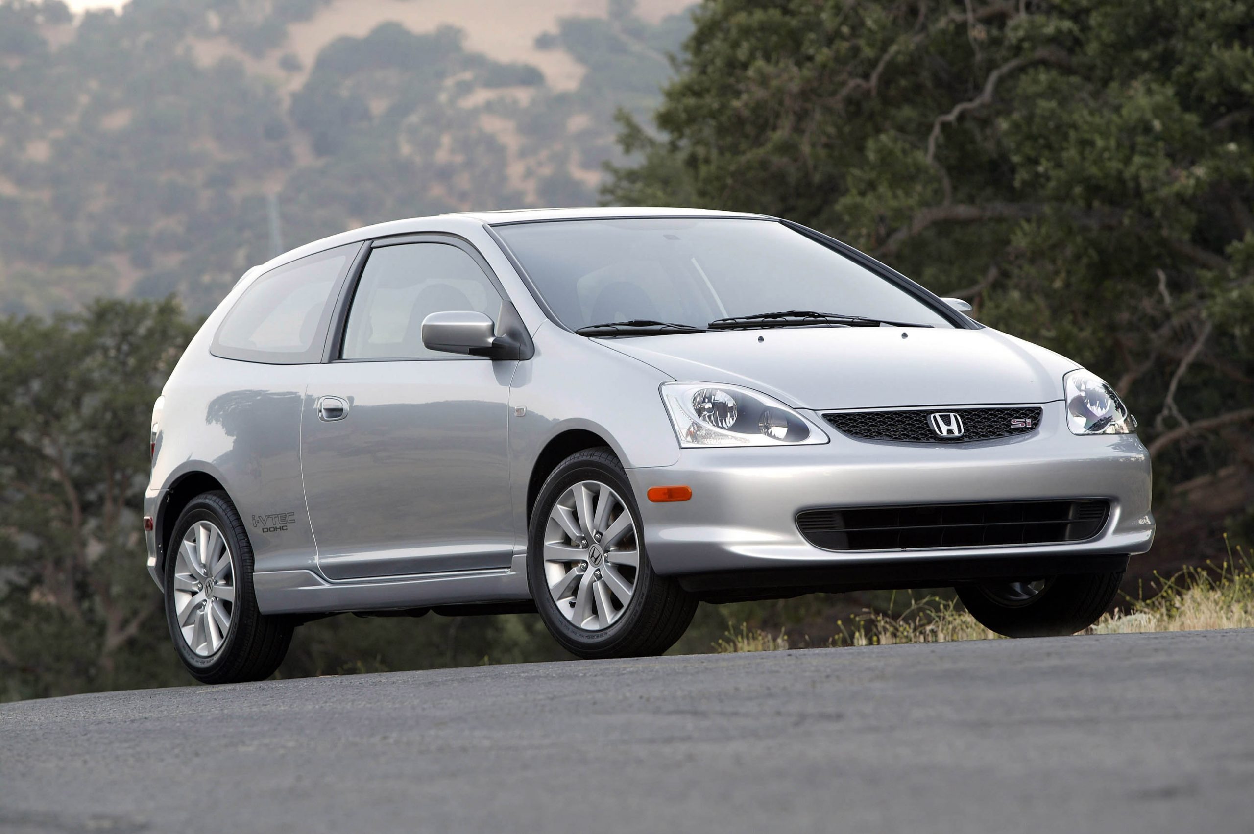 A silver 2005 Civic Si shot from the low 3/4 angle on a back road