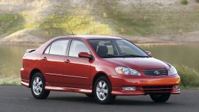 A red '05 Toyota Corolla shot from the front 3/4 during the golden hour