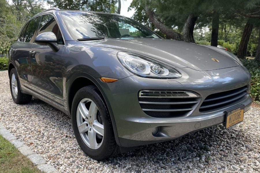 A gray 2012 Porsche Cayenne manual parked on a gravel driveway