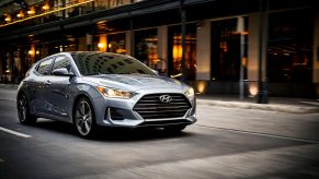 A gray 2021 Hyundai Veloster 2.0 drives through a city