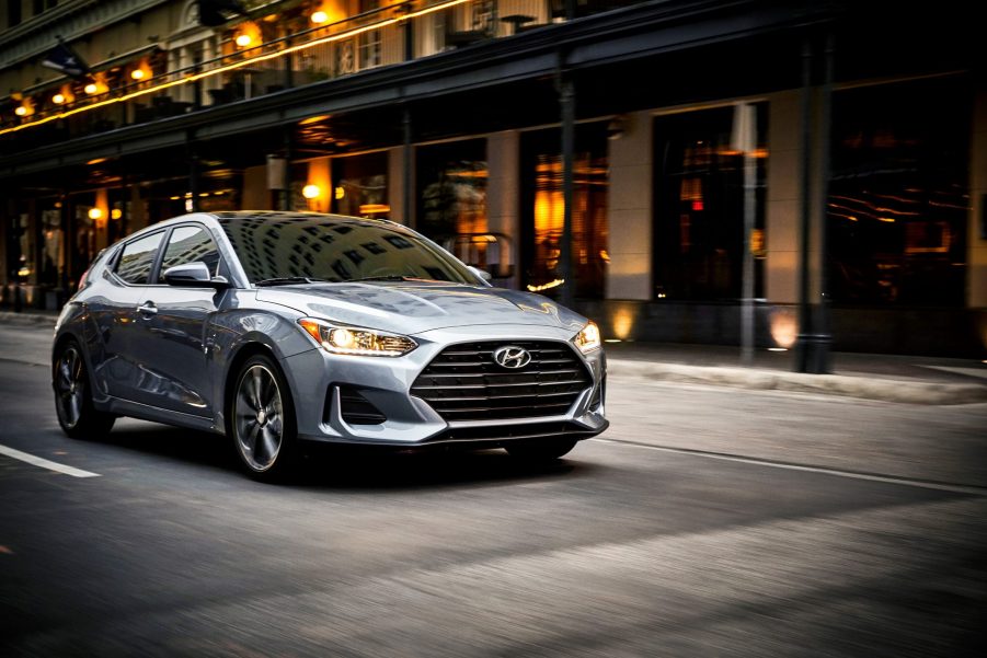 A gray 2021 Hyundai Veloster 2.0 drives through a city