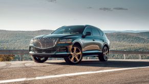 A 2022 Genesis GV80 midsize luxury SUV parked on the side of a country highway