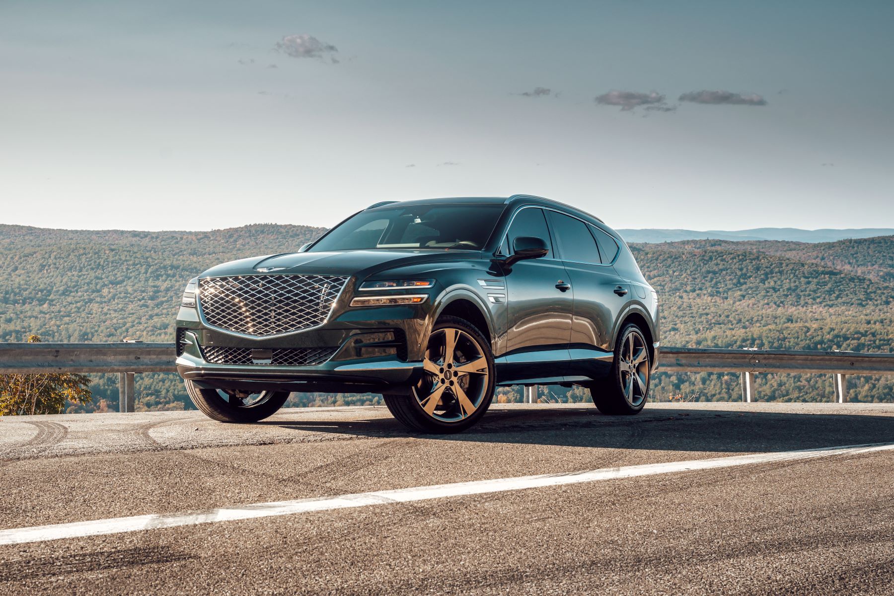 A 2022 Genesis GV80 midsize luxury SUV parked on the side of a country highway