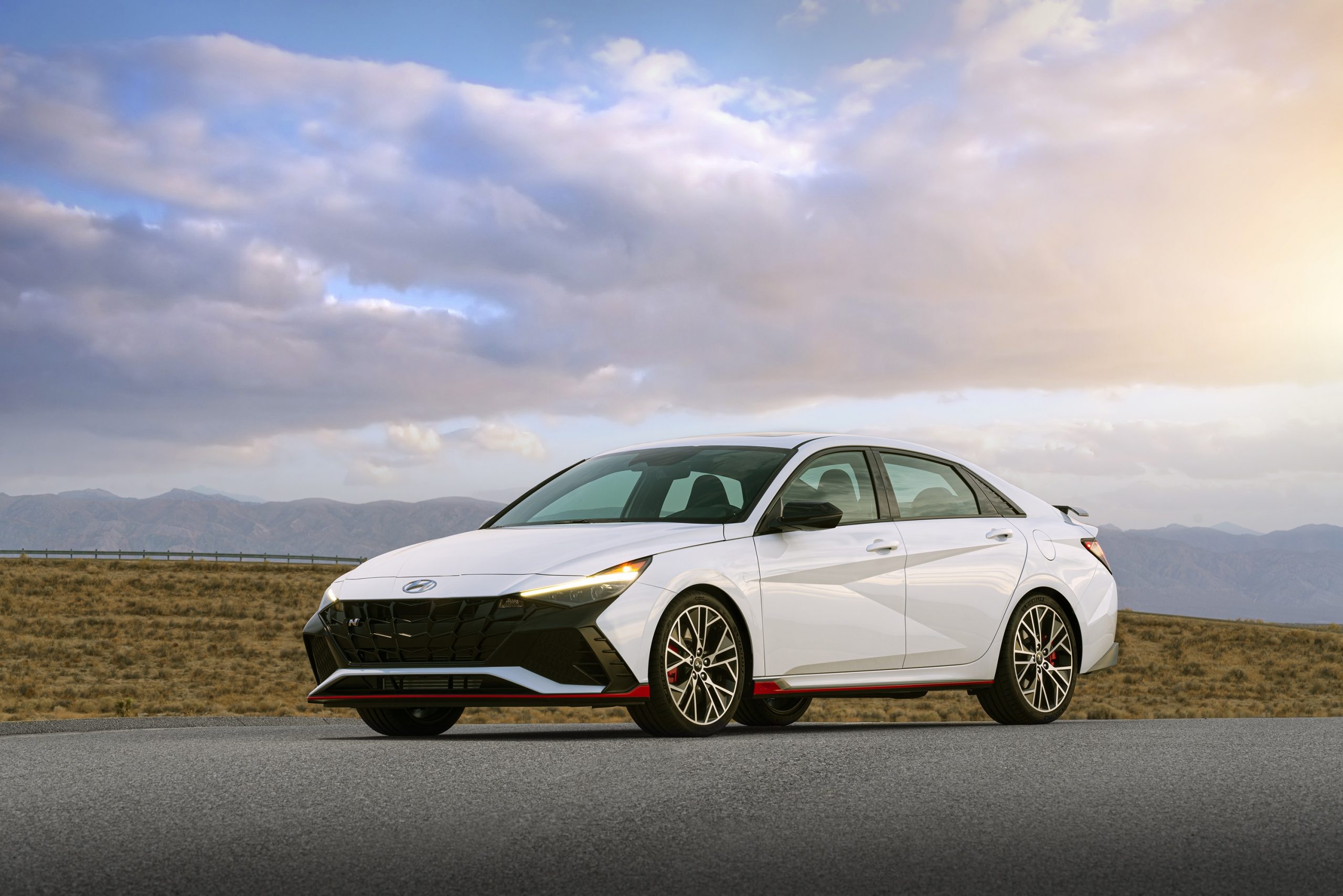 A white 2022 Hyundai Elantra N shot from the front 3/4 at sunset