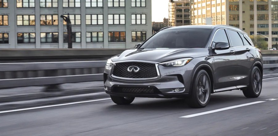 A gray 2022 Infiniti QX50 driving on a road, it gained new tech upgrades for the new model year.