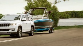 A white 2022 Jeep Wagoneer towing a boat.