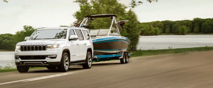 A white 2022 Jeep Wagoneer towing a boat.