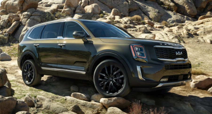 A green 2022 Kia Telluride against rocks.