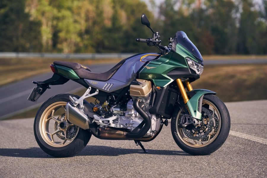 A green-and-silver 2022 Moto Guzzi V100 Mandello parked on a curving road