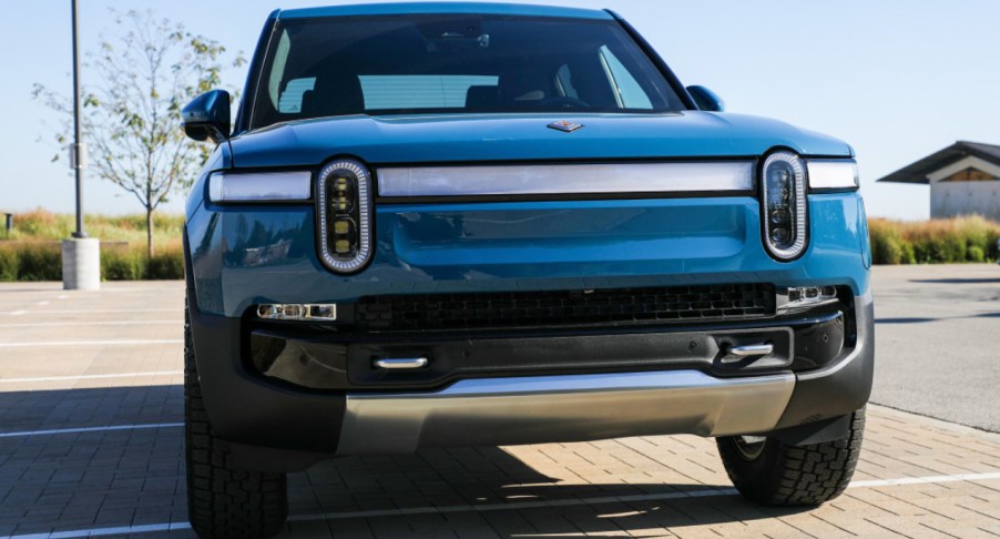 A blue 2022 Rivian R1T electric pickup truck is parked.