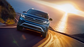 A blue 2022 Volkswagen Atlas drives on a winding road during a sunset in the background, how much does a fully loaded one cost?