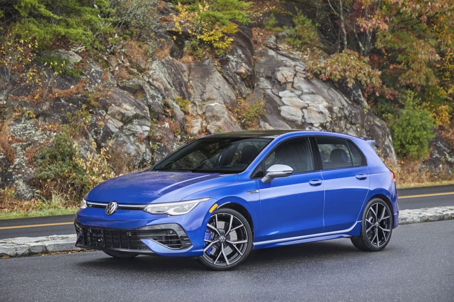 A blue 2022 Volkswagen Golf R parked by a rocky cliff