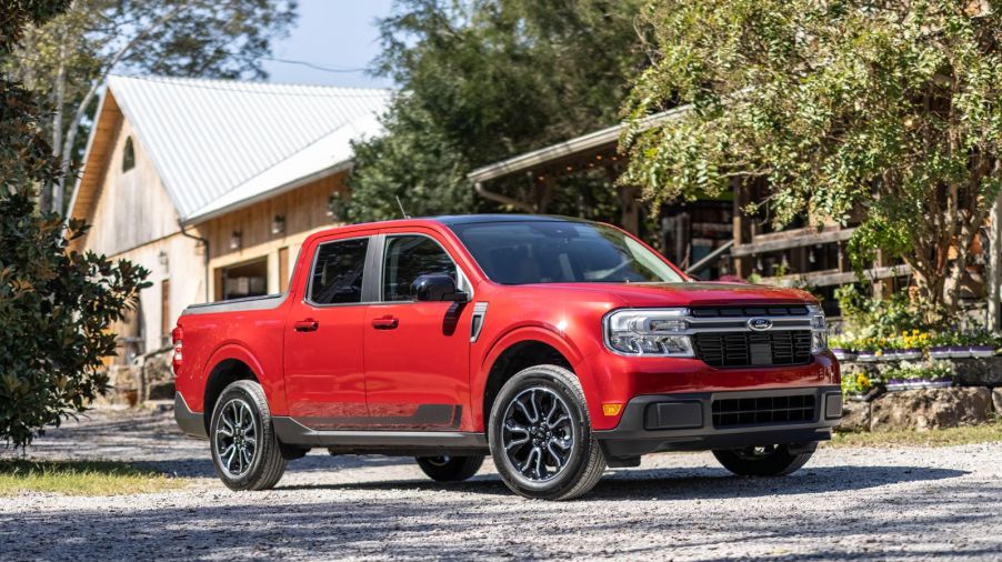 A red 2022 Ford Maverick is parked outside of a house.