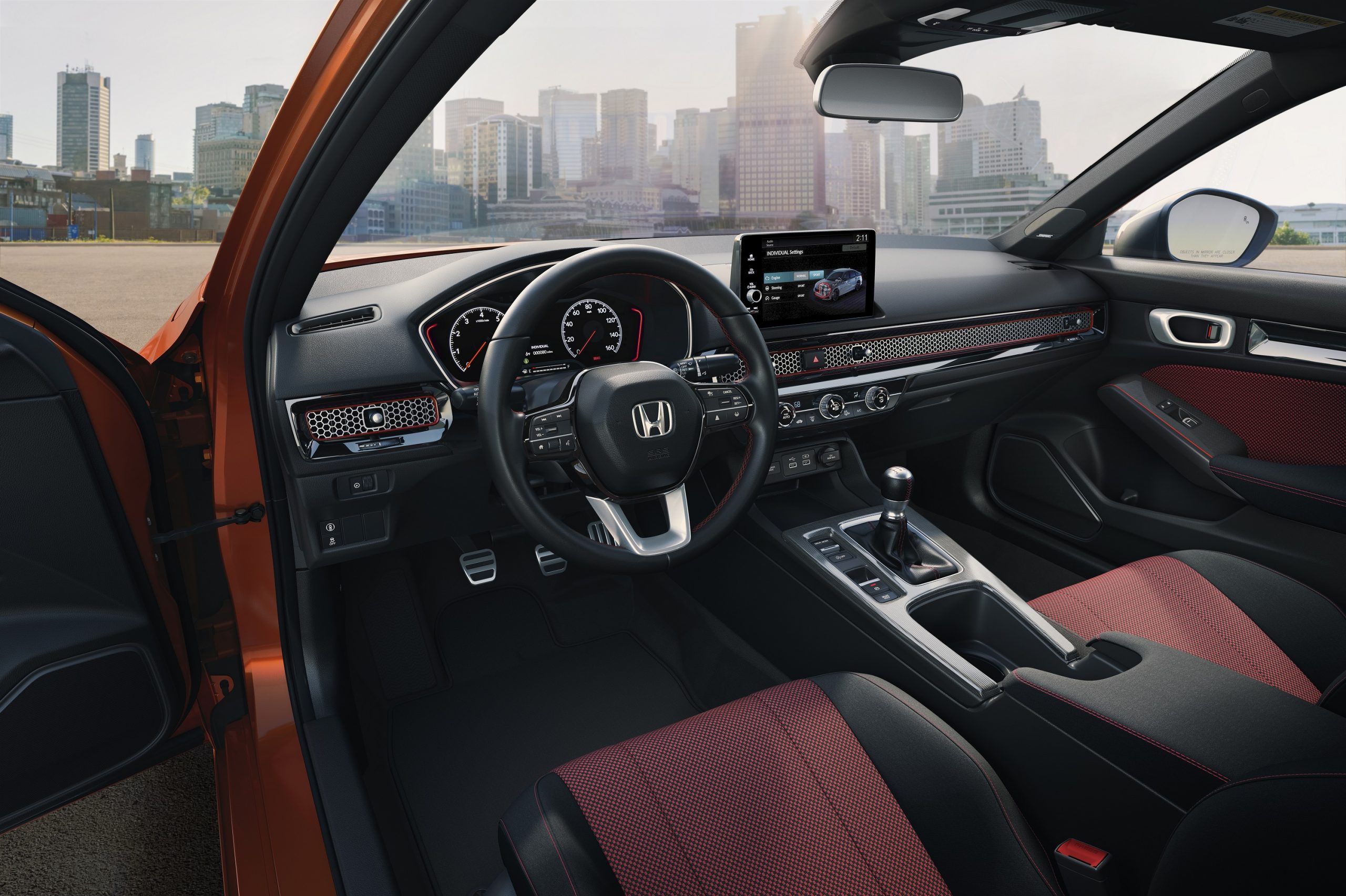 The interior of the new Civic Si in red cloth with a manual transmission.