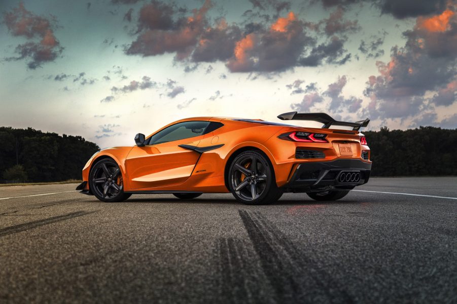 The rear 3/4 view of an orange 2023 Chevrolet Corvette Z06 on a racetrack