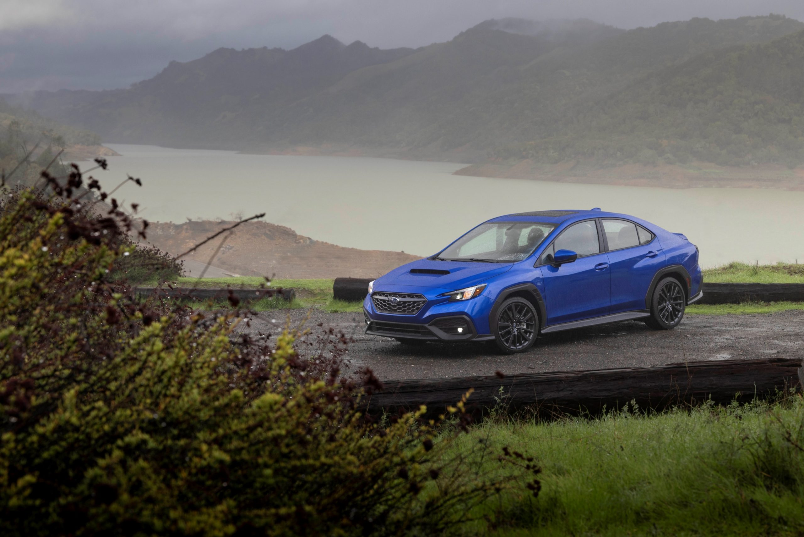 A rally blue 2022 Subaru WRX AWD sedan shot on a rainy day