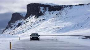 A car driving on a snowy road, highlighting how bald tires are dangerous for winter driving