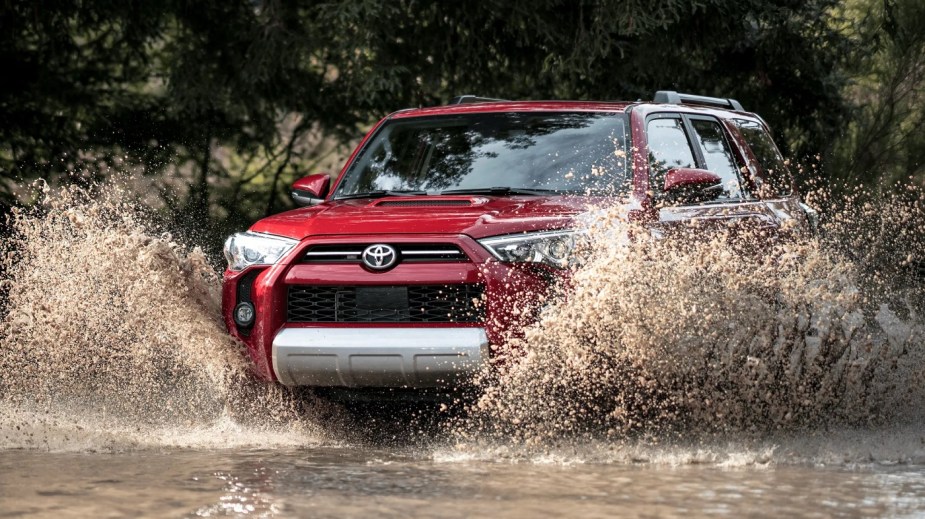 A red 2022 Toyota 4Runner splashing through a puddle.