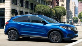 A blue 2022 Honda HR-V driving through a city.