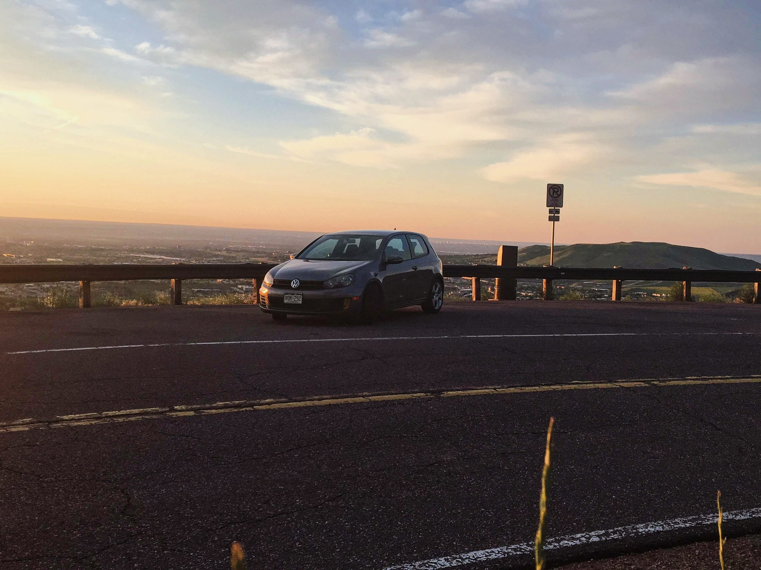 A United Grey Metallic 2010 Volkswagen GTI hatchback shot from the front 3/4 at sunrise