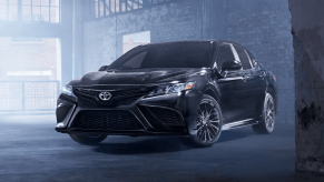 Midnight Black Metallic 2022 Toyota Camry parked inside an old brick building