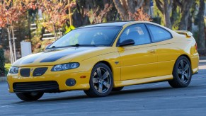 A modified yellow-and-black 2004 Pontiac GTO on a street