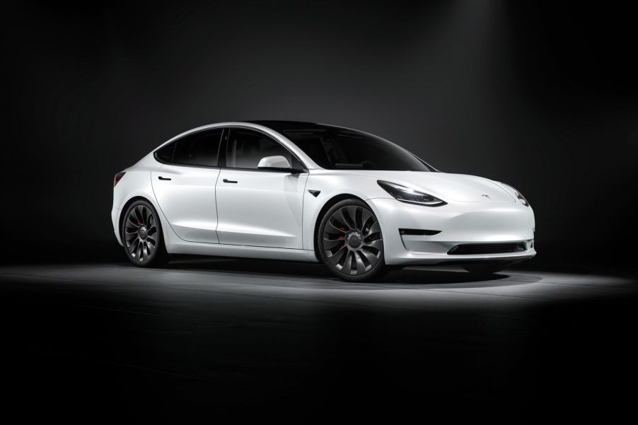 Passenger's side view of white 2022 Tesla Model 3, a car that has high gas mileage and fast acceleration