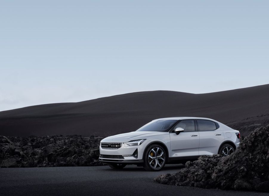 A white Polestar 2 with brown hills in the background.