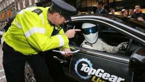 Police officer gives a speeding ticket fine to a driver