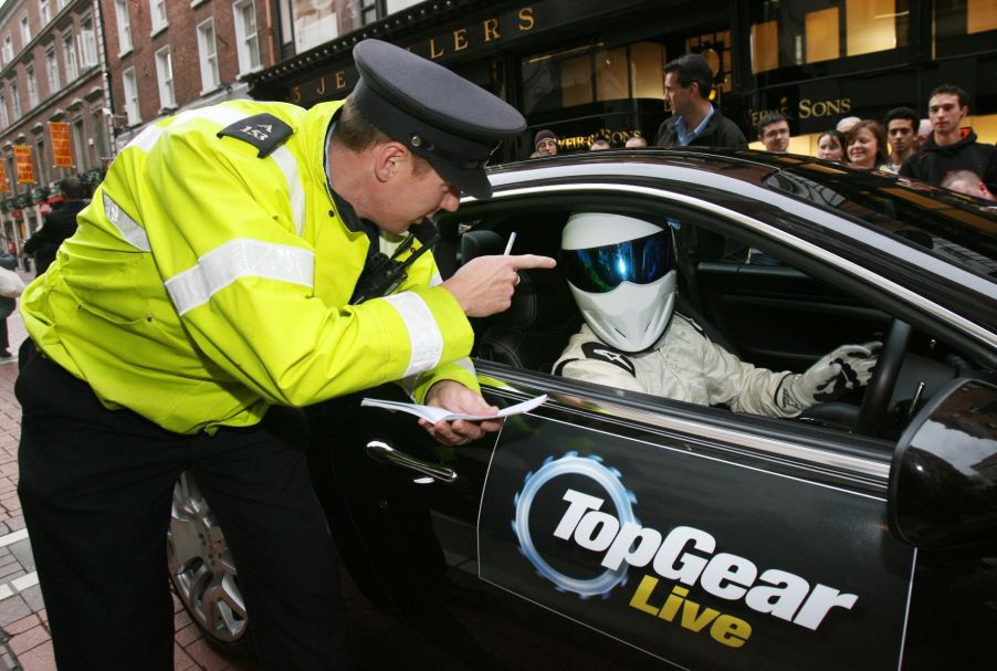 Police officer gives a speeding ticket fine to a driver