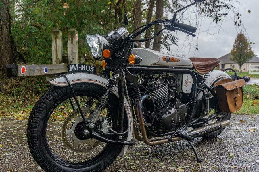 A white-and-gold pre-production 2021 Janus Halcyon 450 on a rainy forest path