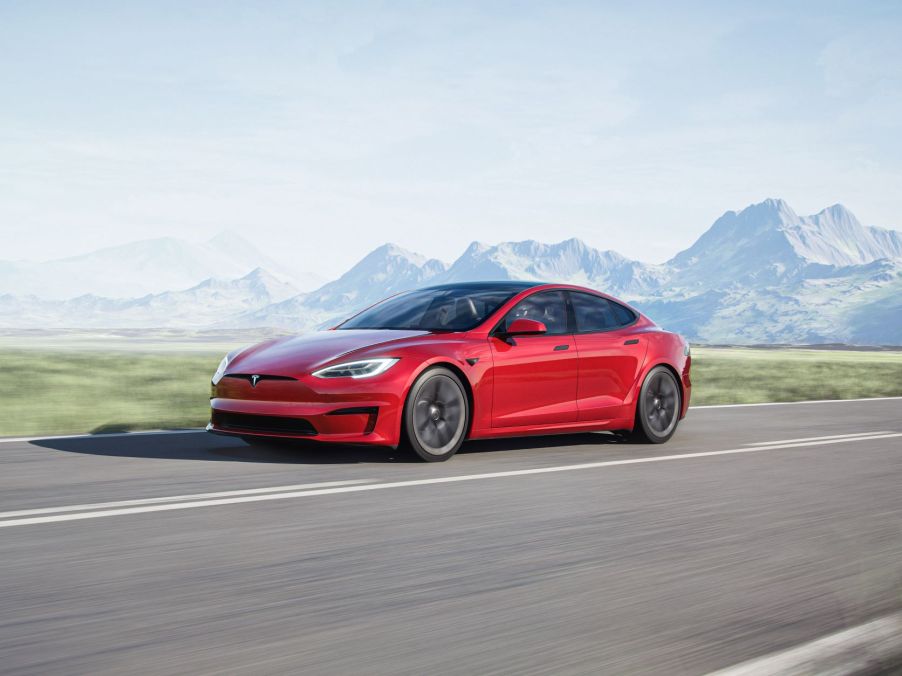 A fully loaded red 2022 Tesla Model S driving on a curvy road