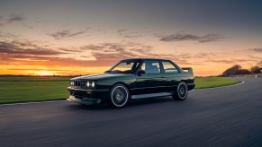 A black Redux Enhanced & Evolved BMW E30 M3 drives around a track