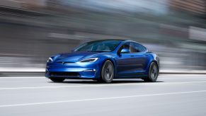 A blue 2022 Tesla Model Y racing down a street.