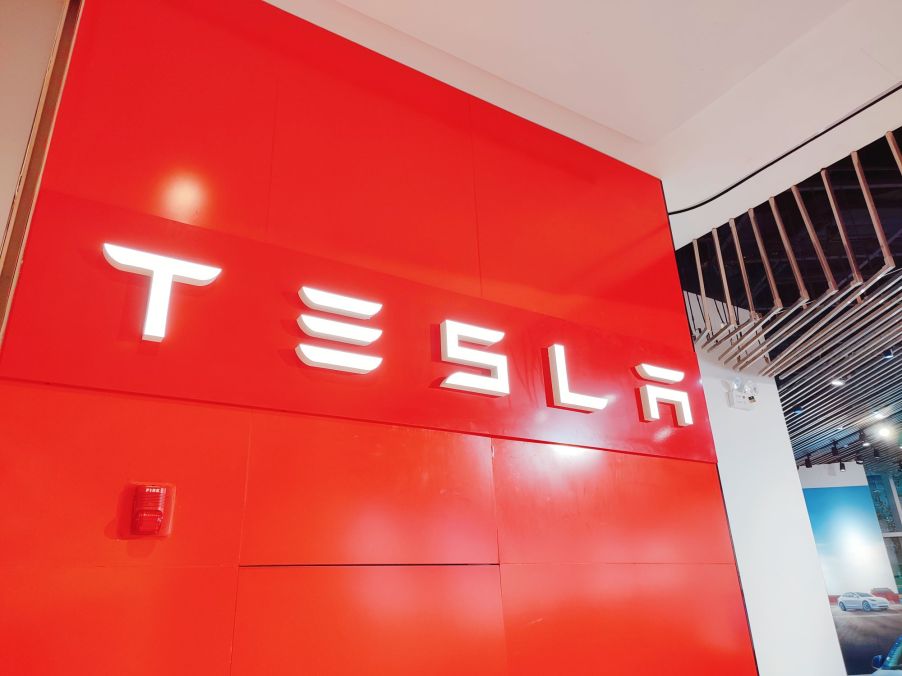 Red Telsa sign with Tesla written in white.