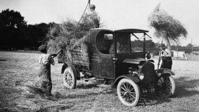 Pitching hay into a Ford Model T Pickup truck | Topical Press Agency/Getty Images