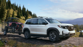 White 2022 Honda Passport Elite towing an ATV