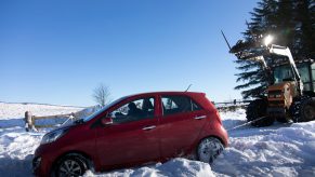 A stranded car being hauled out of a snow bank