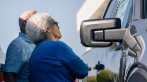 Woman and man looking at a Moroney Sticker on a truck.