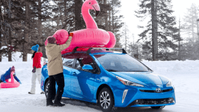 Woman placing a pink inflatable on a 2022 Toyota Prius