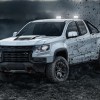 A white 2022 Chevy Coloardo off-roading in dirt and rocks.