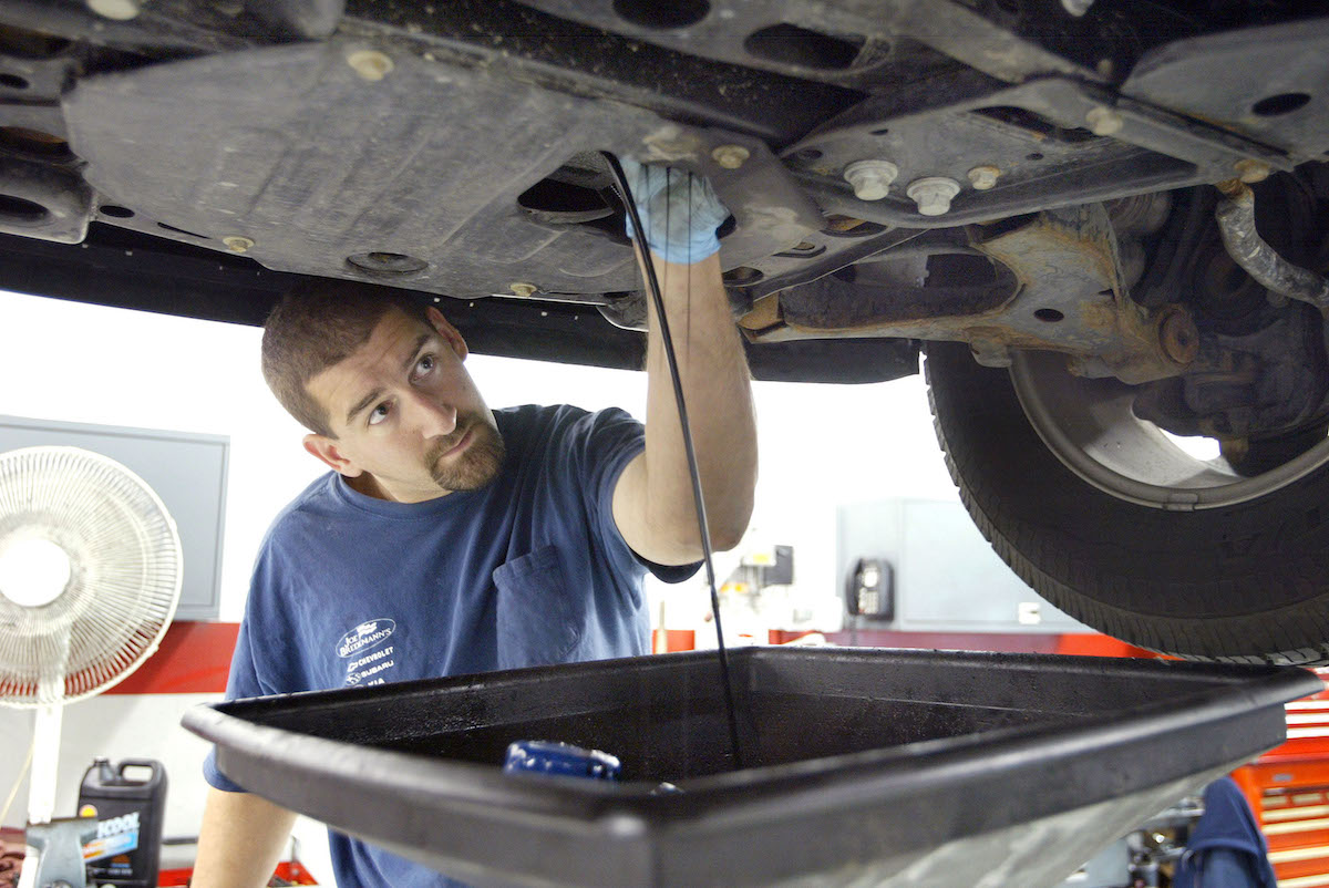 A vehicle gets an oil change in a service garage