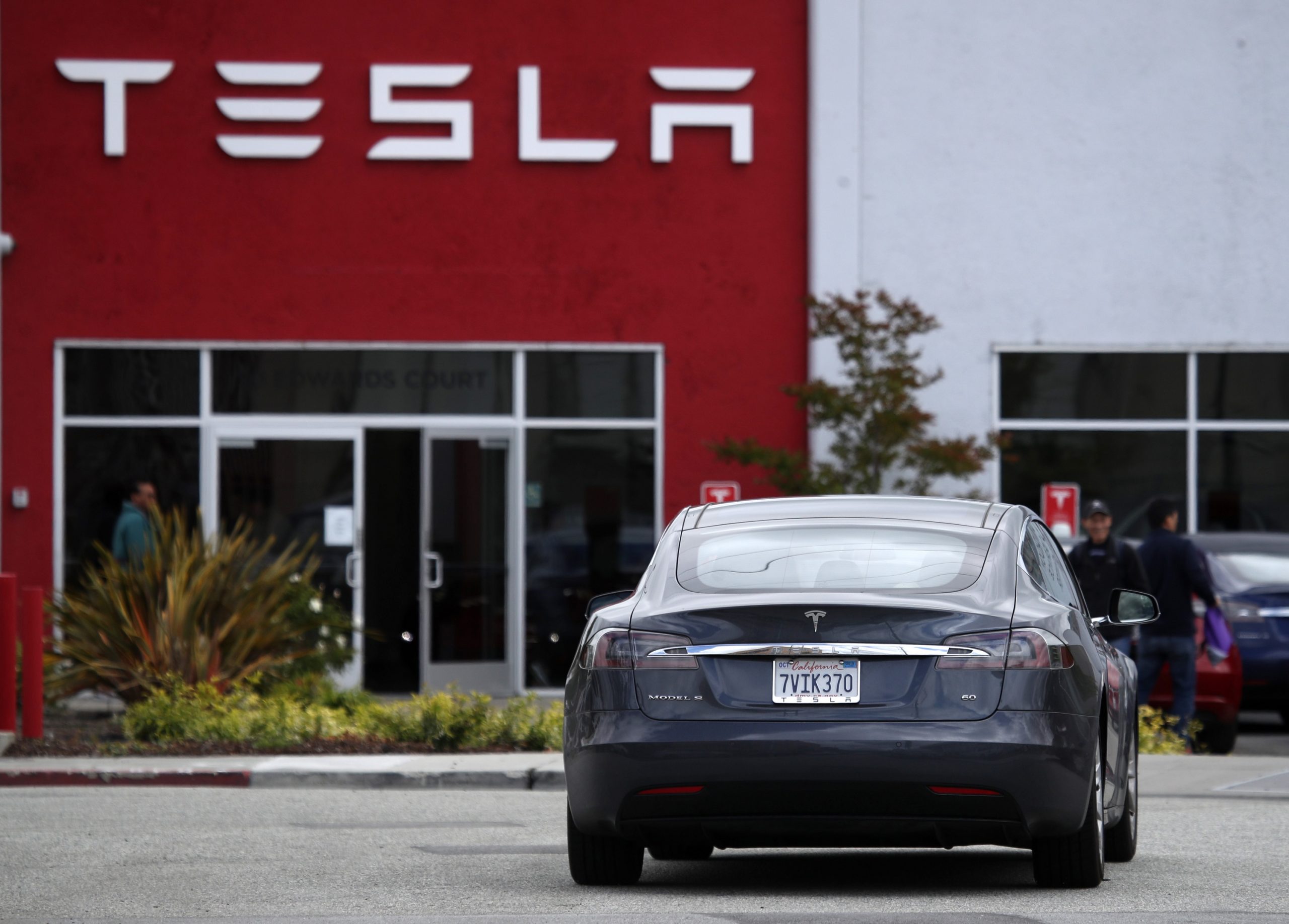 A Tesla Model S, also affected by the Tesla recall, sits outside a dealership showroom