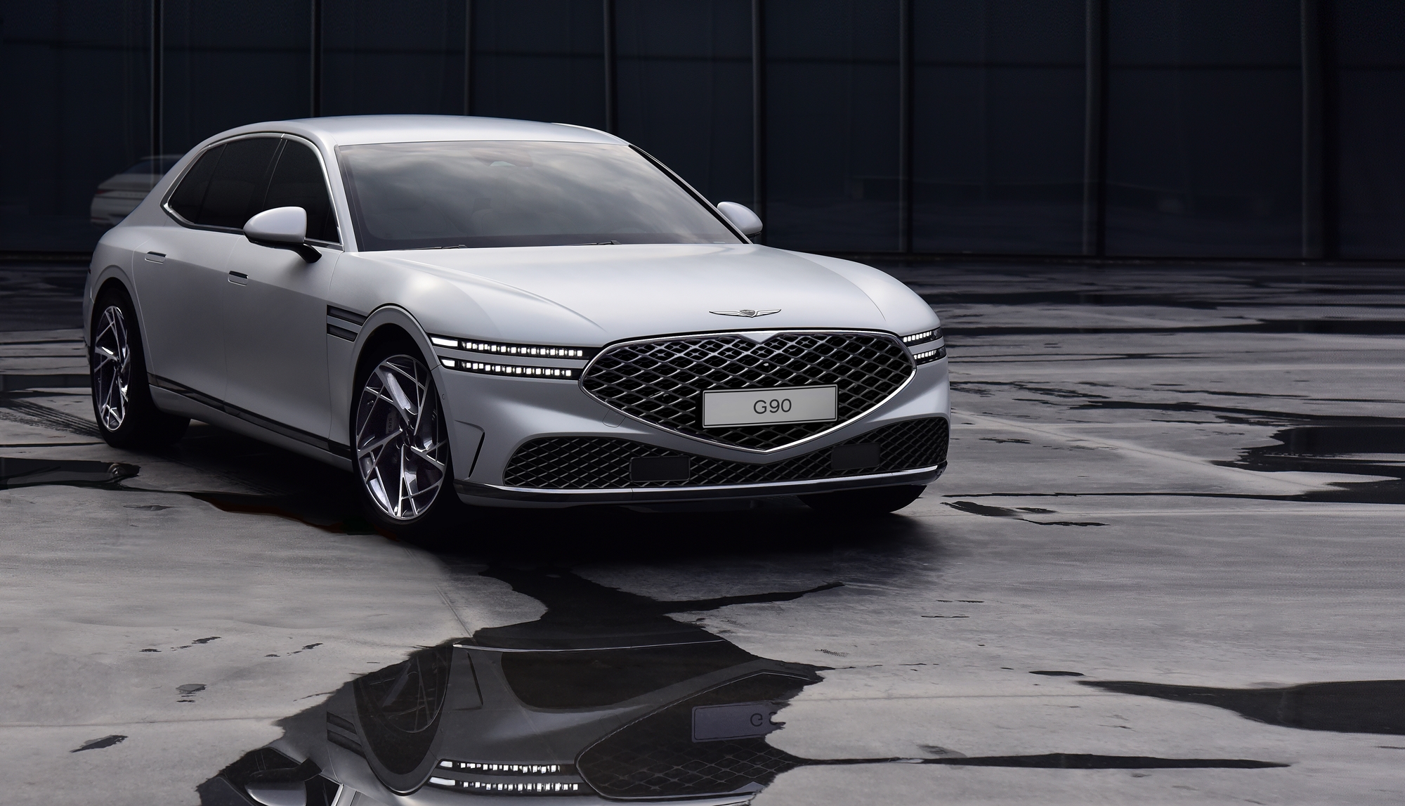 A white Genesis G90 luxury sedan shot from the front 3/4