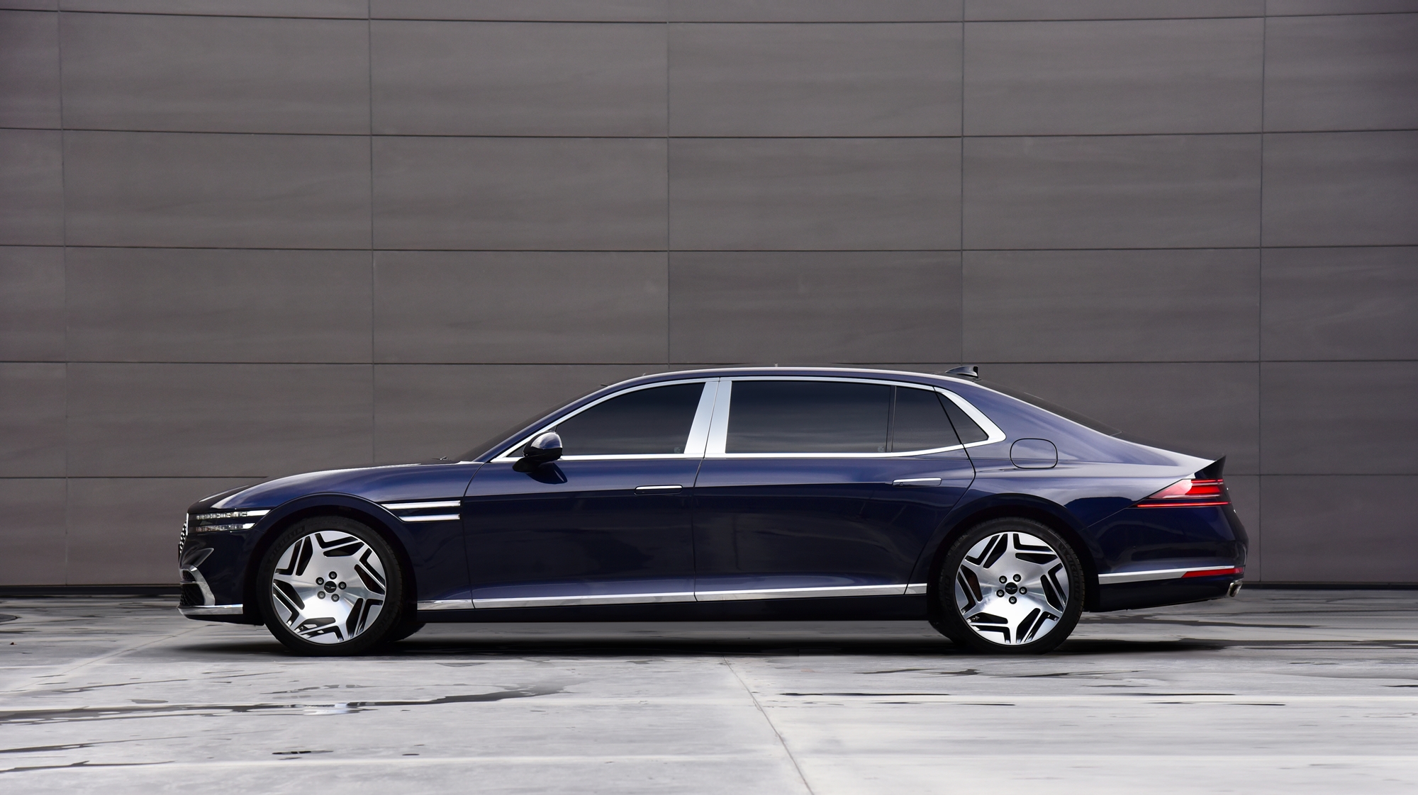 A dark blue Genesis G90 shot in profile