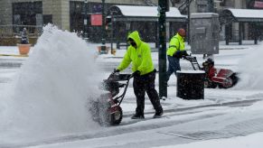 A pair of Public Works city workers clearing snow on a street using snow blowers in Reading, Pennsylvania